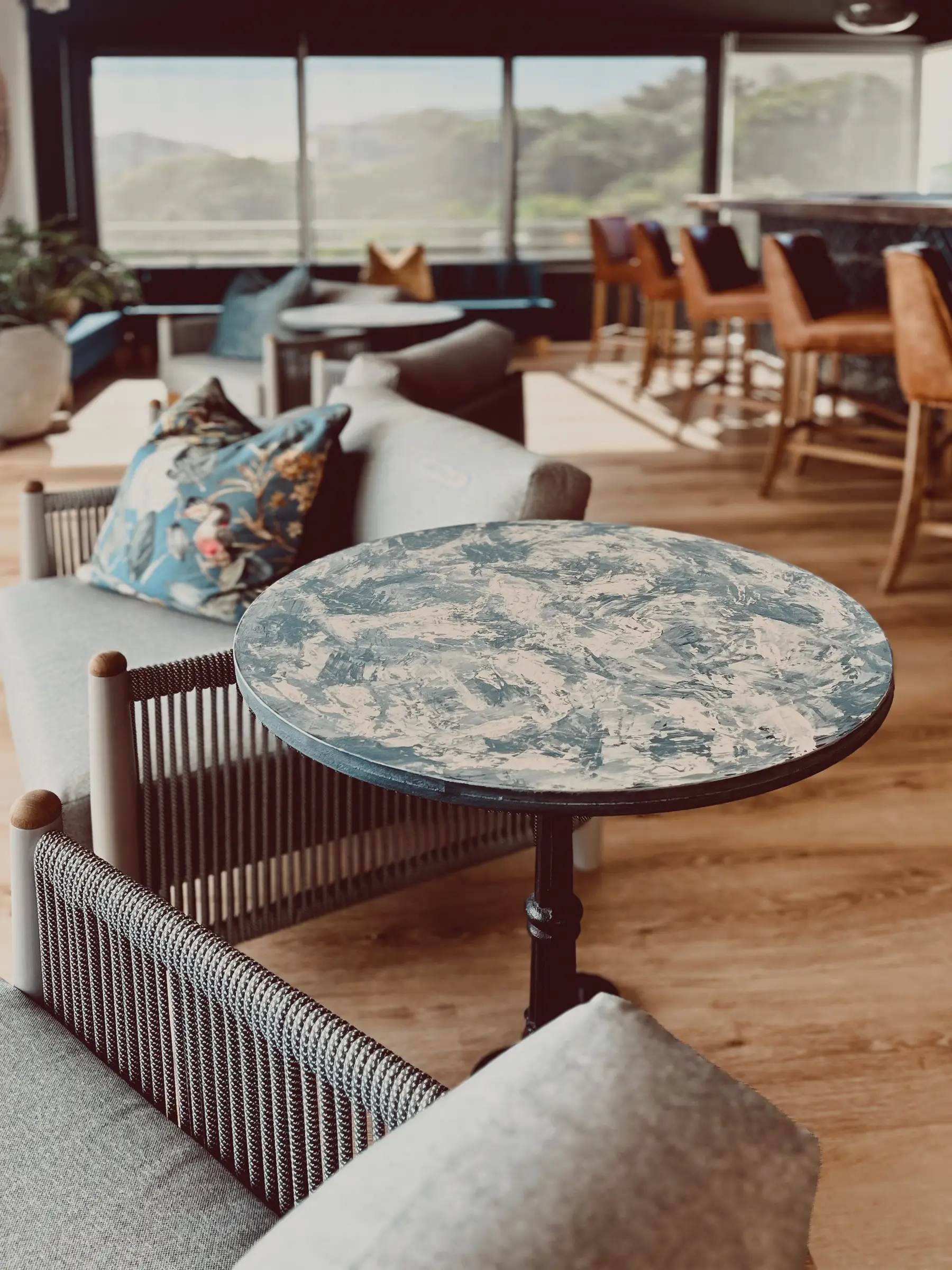 Hand-painted small round dining area table with updated lounge furniture inside Glentana building.