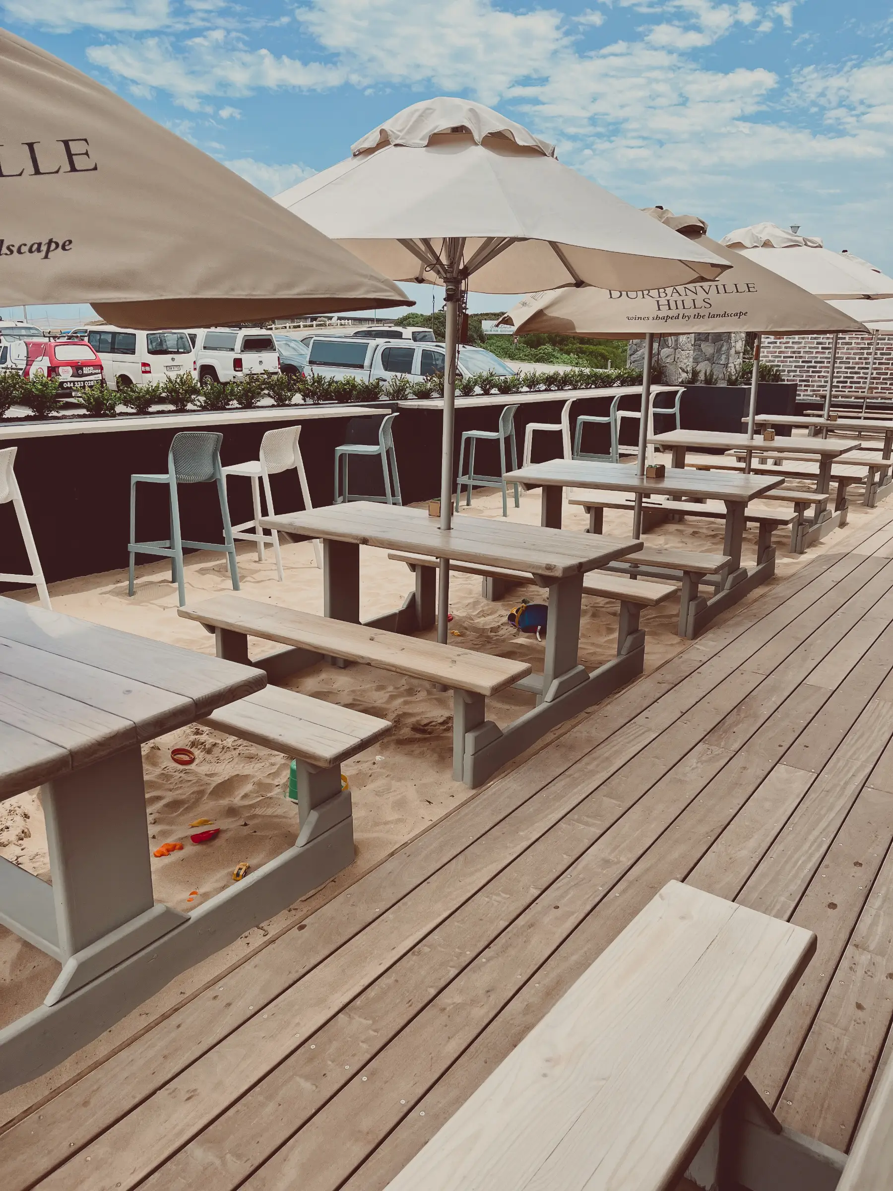 Renovated outer deck area with picnic tables, umbrellas and sea sand.